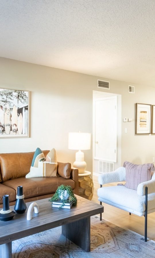 a living room with a couch, coffee table and chairs at The  Rowen