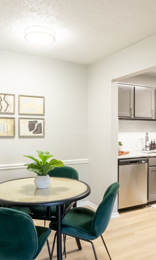 a dining room with a table and chairs and a kitchen at The  Rowen