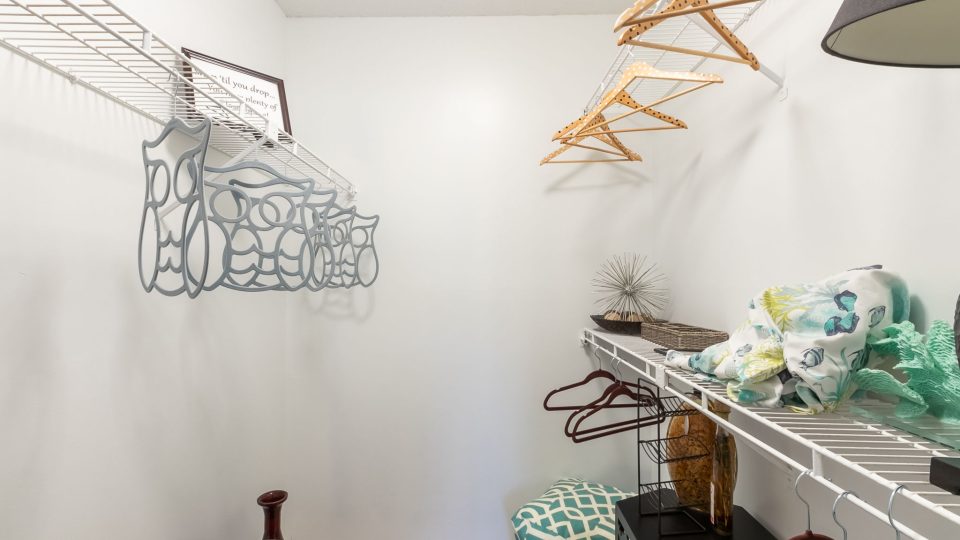 a closet with clothes hanging on the shelves at The  Rowen