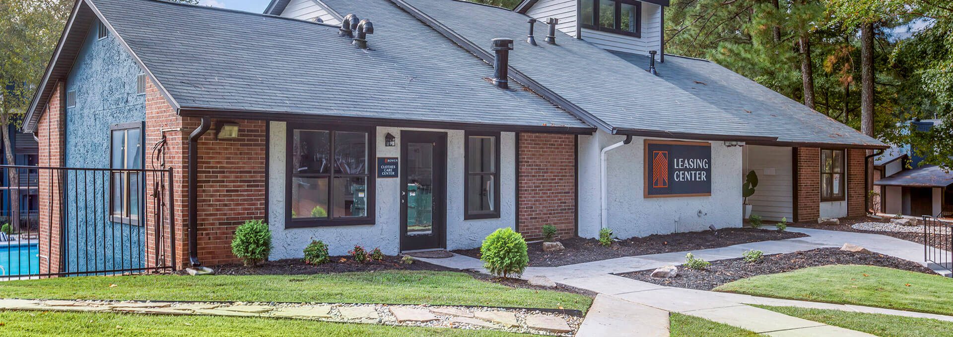 a brick home with a pool and grass at The  Rowen