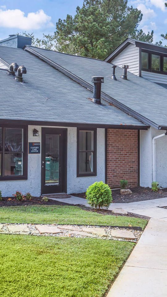 a brick home with a pool and grass at The  Rowen