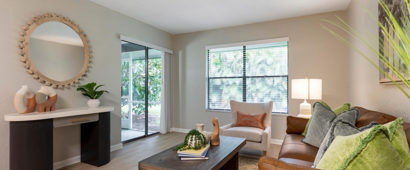 a living room with a couch, coffee table and mirror at The Marino