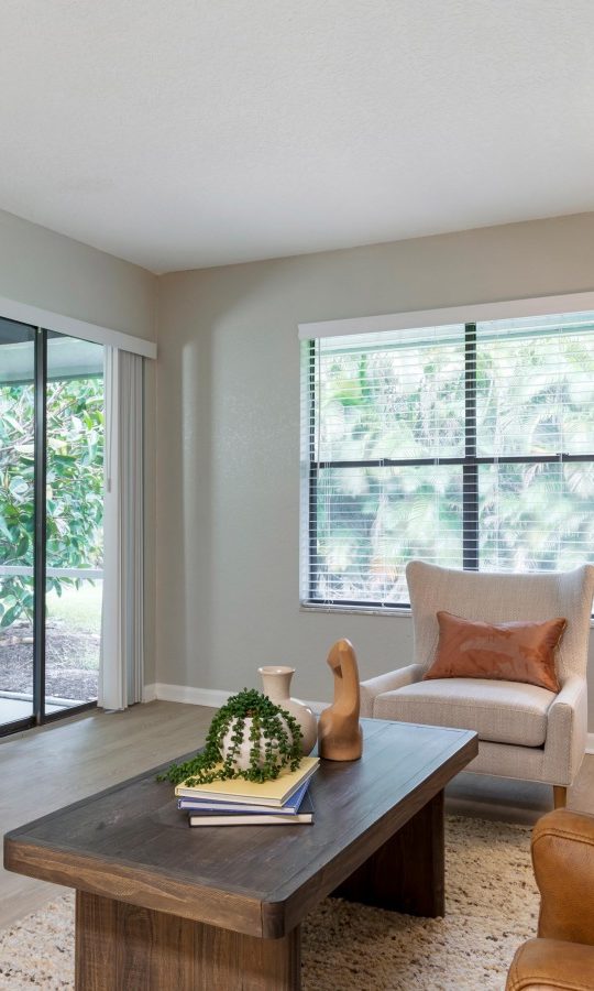 a living room with a couch, coffee table and mirror at The Marino