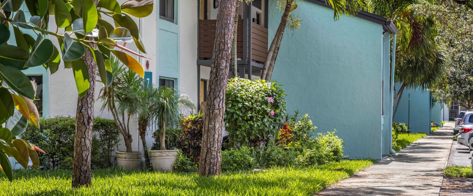 a walkway with trees and bushes in front of a building at The Marino