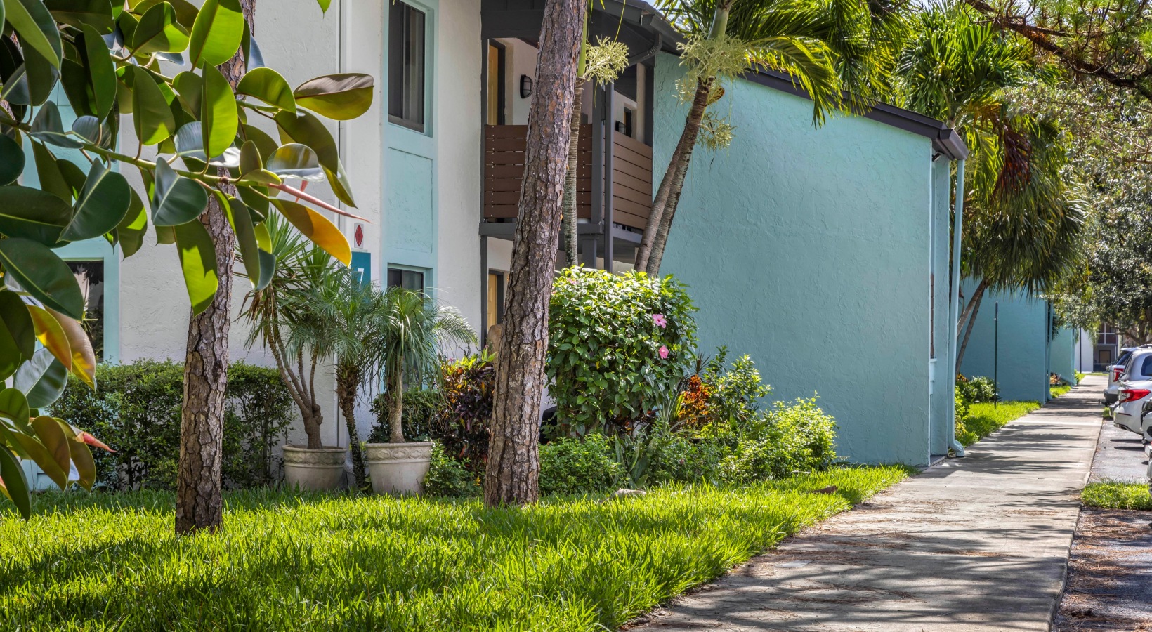 a walkway with trees and bushes in front of a building at The Marino