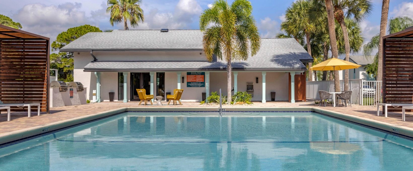 a pool with lounge chairs and palm trees in front of it at The Marino
