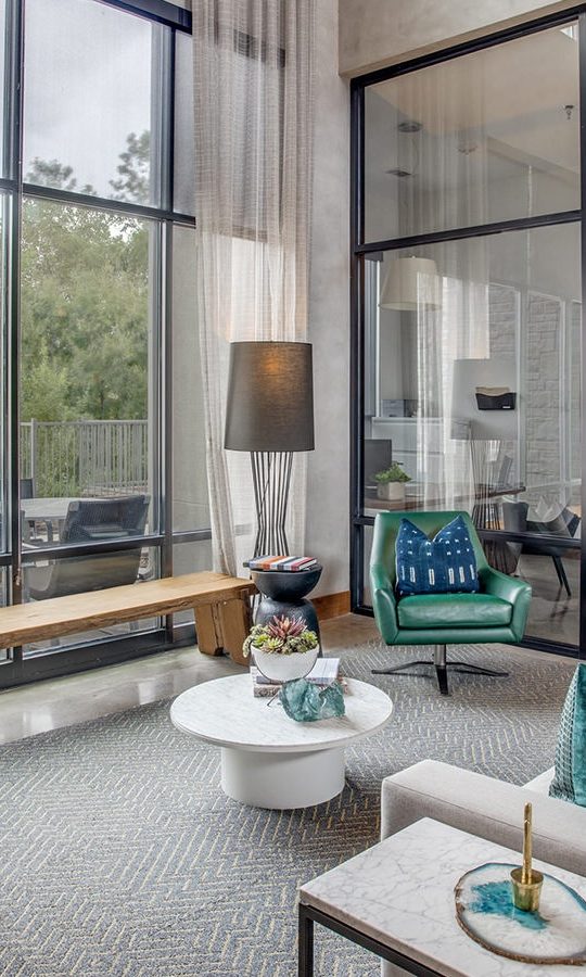 a living room with large windows and a couch at The Twin Creeks Crossing