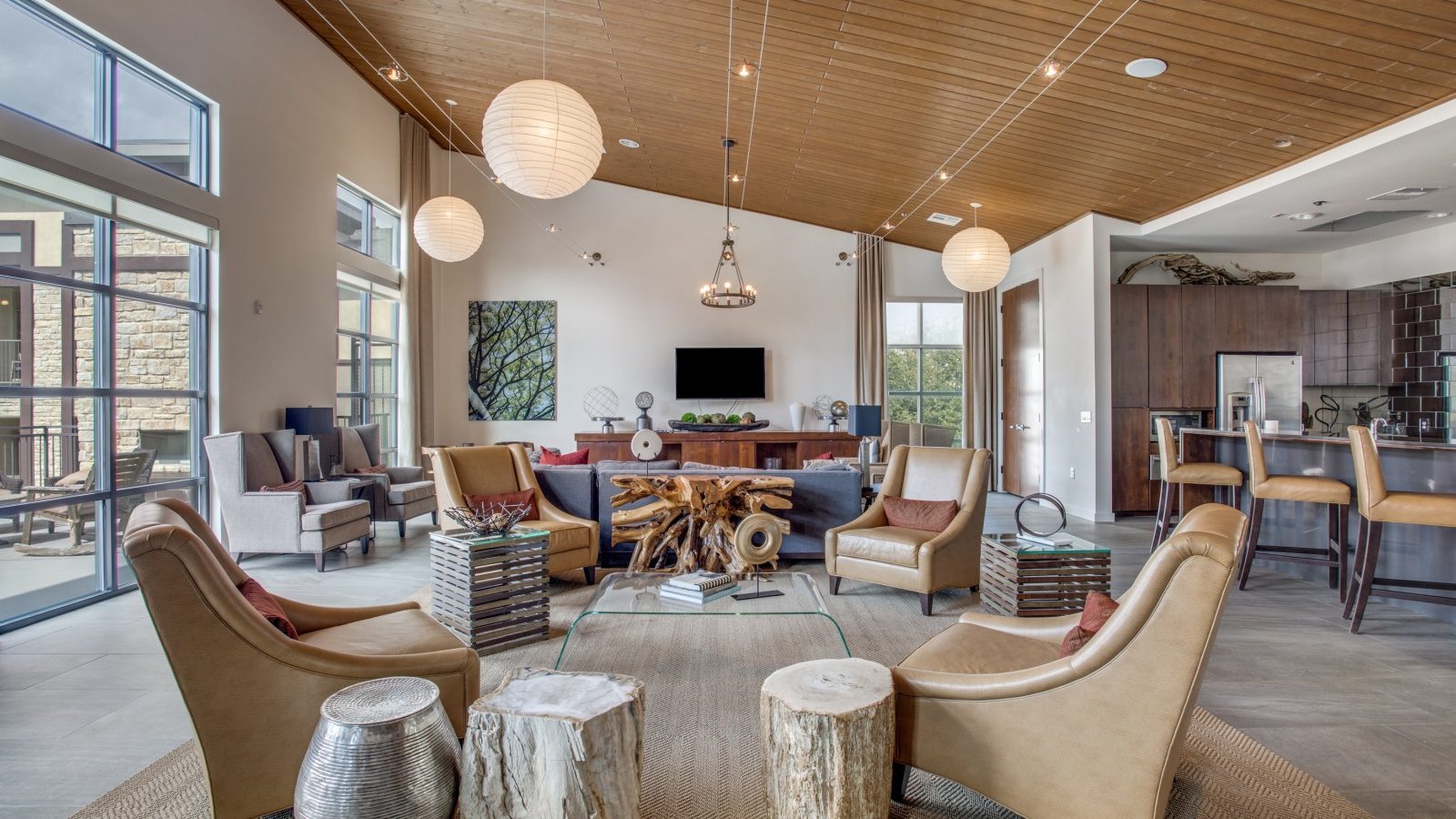 a large open living room with wood ceiling and a fireplace at The Twin Creeks Crossing
