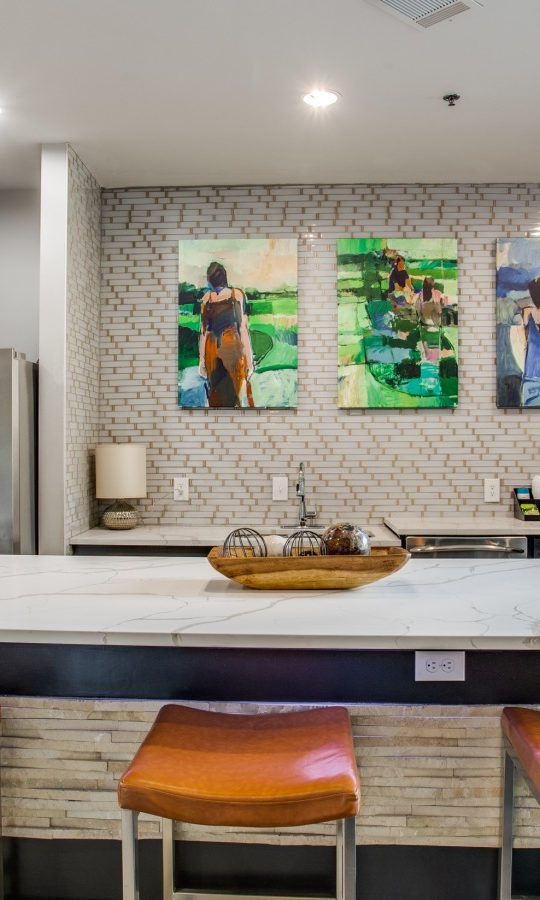 a kitchen with a large island and bar stools at The  Franklin at Samuels Ave