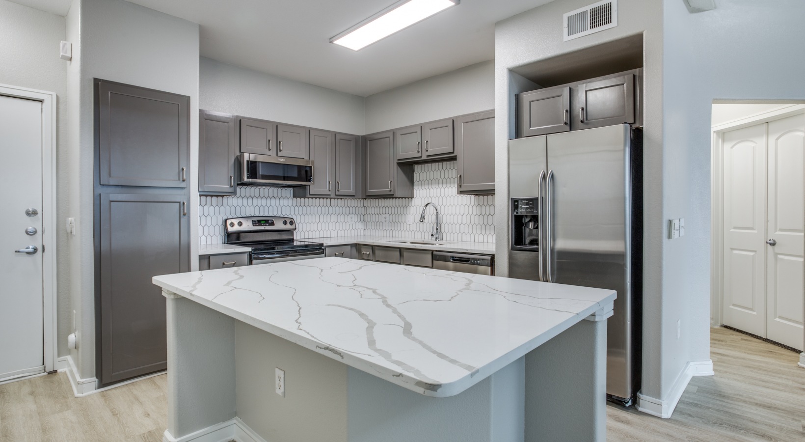 a kitchen with stainless steel appliances and granite counter tops at The Franklin at Samuels Ave