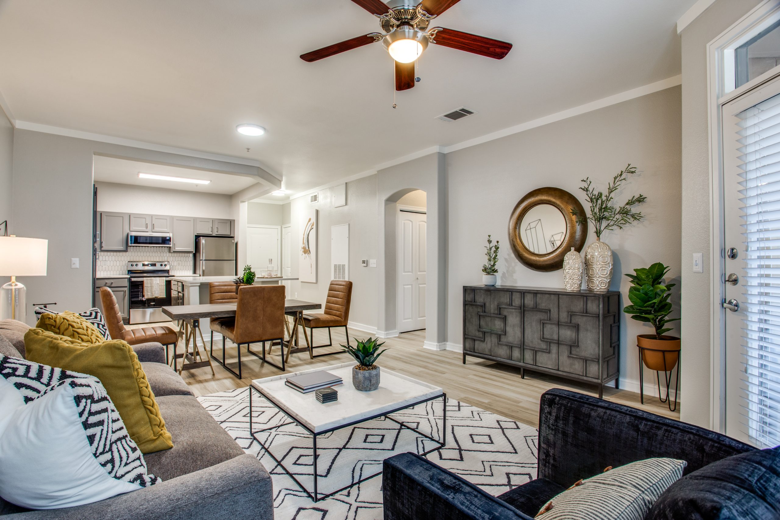 a living room with a ceiling fan and a couch at The Franklin at Samuels Ave