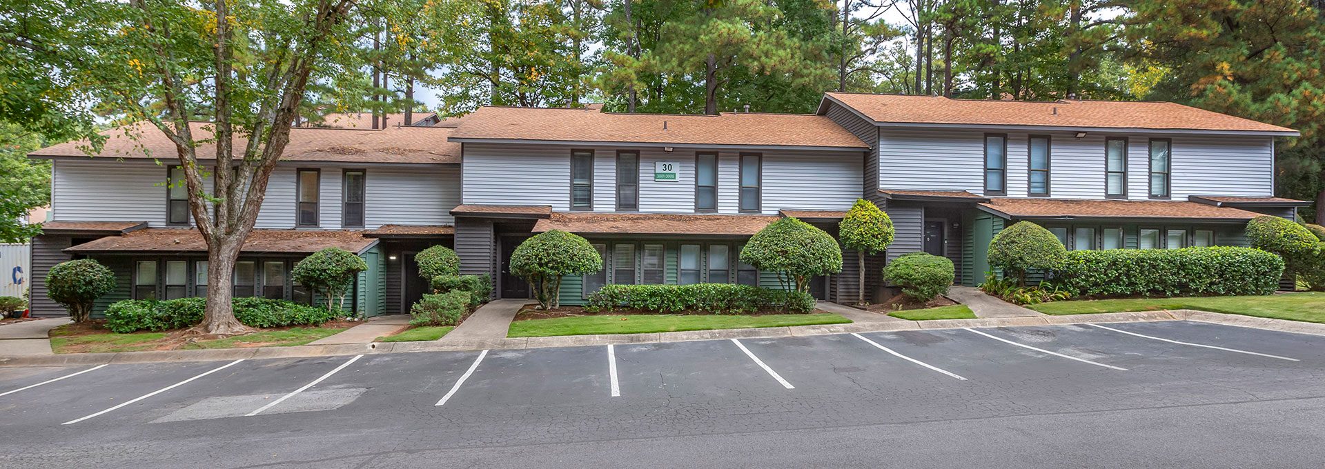 the exterior of an apartment complex with parking lot at The  Breck
