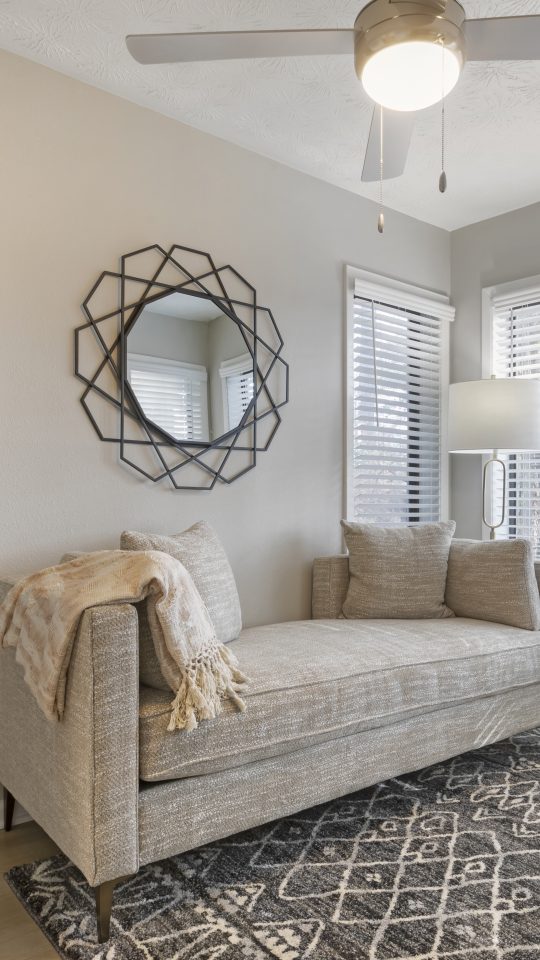 a bedroom with a couch and a fan at The  Breck