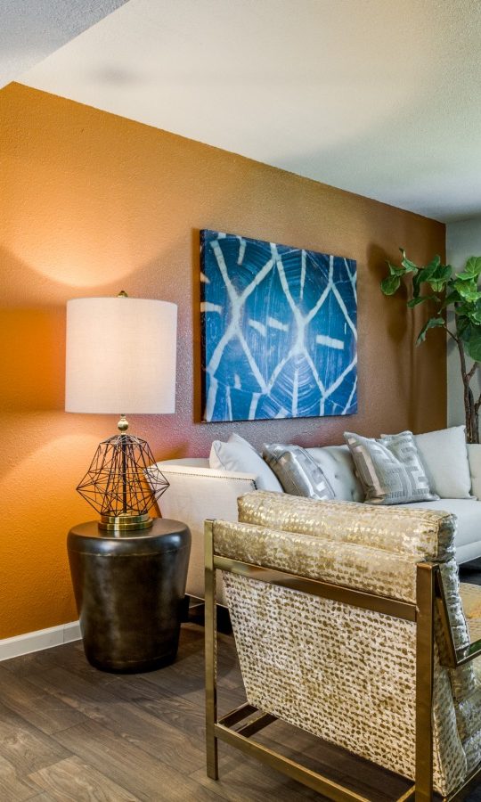 a living room with orange walls and hardwood floors at The Zeke