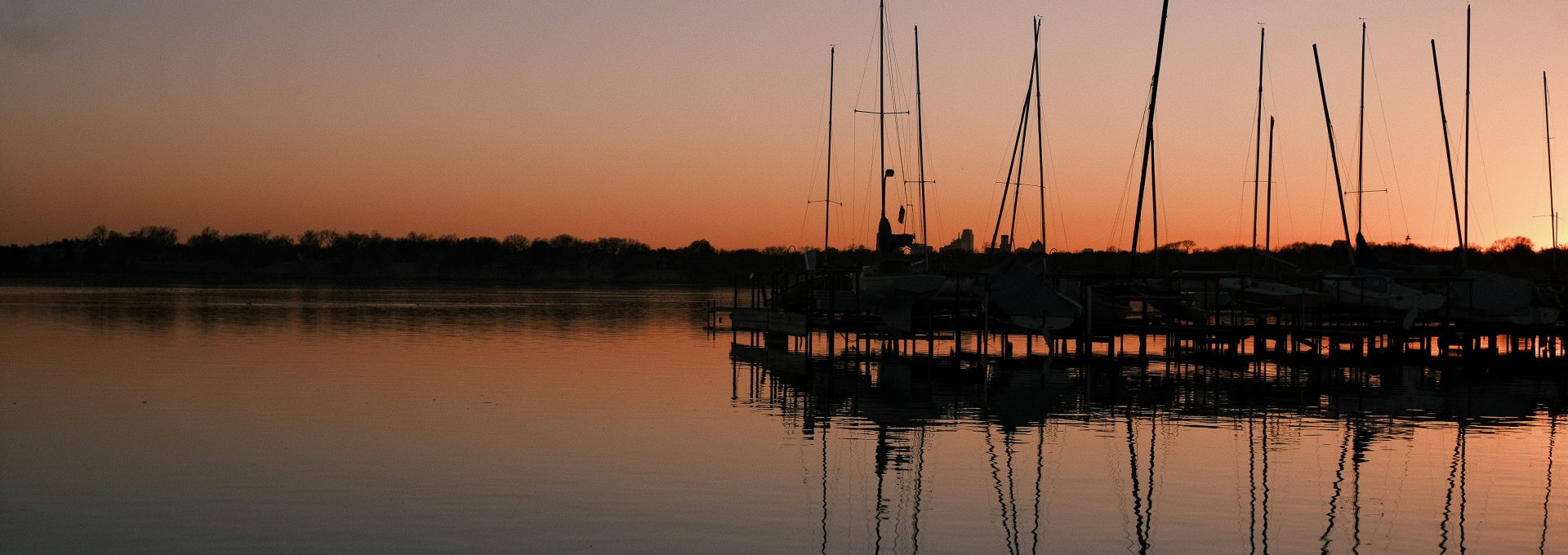 silhouette of boat on sea during sunset