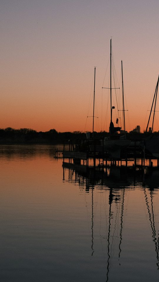 silhouette of boat on sea during sunset