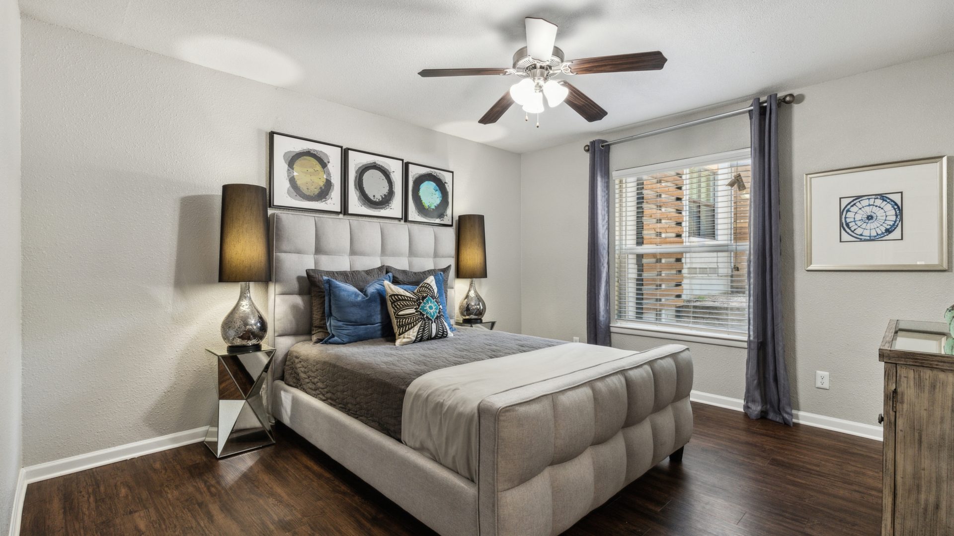 a bedroom with hardwood floors and ceiling fans at The Zeke