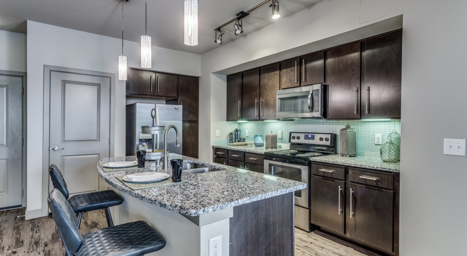 a kitchen with stainless steel appliances and granite counter tops at The  Carson @ Twin Creeks