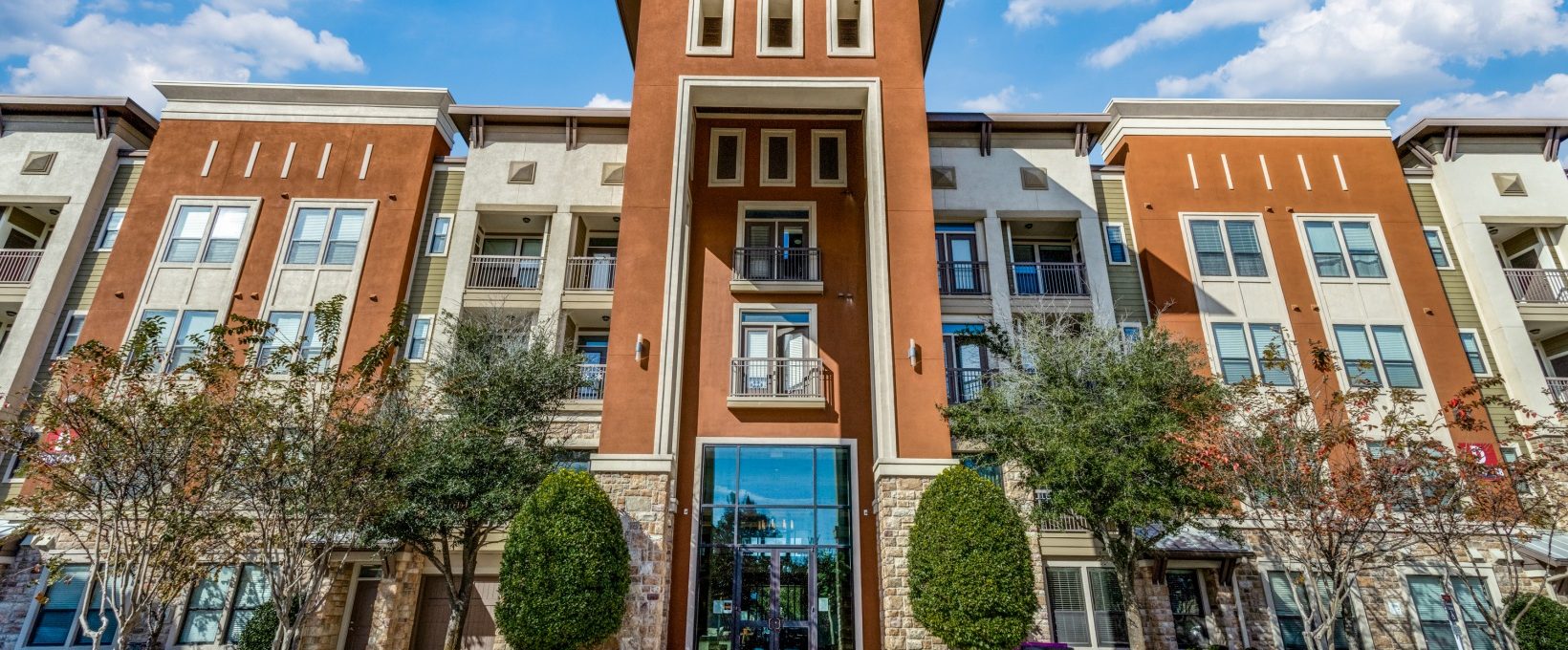 the front entrance to an apartment complex in dallas at The  Carson @ Twin Creeks