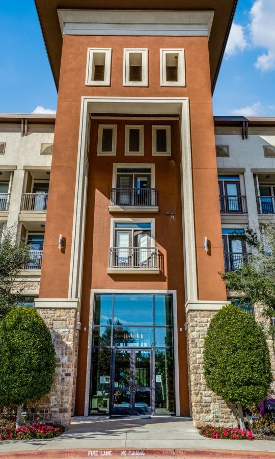 the front entrance to an apartment complex in dallas at The  Carson @ Twin Creeks