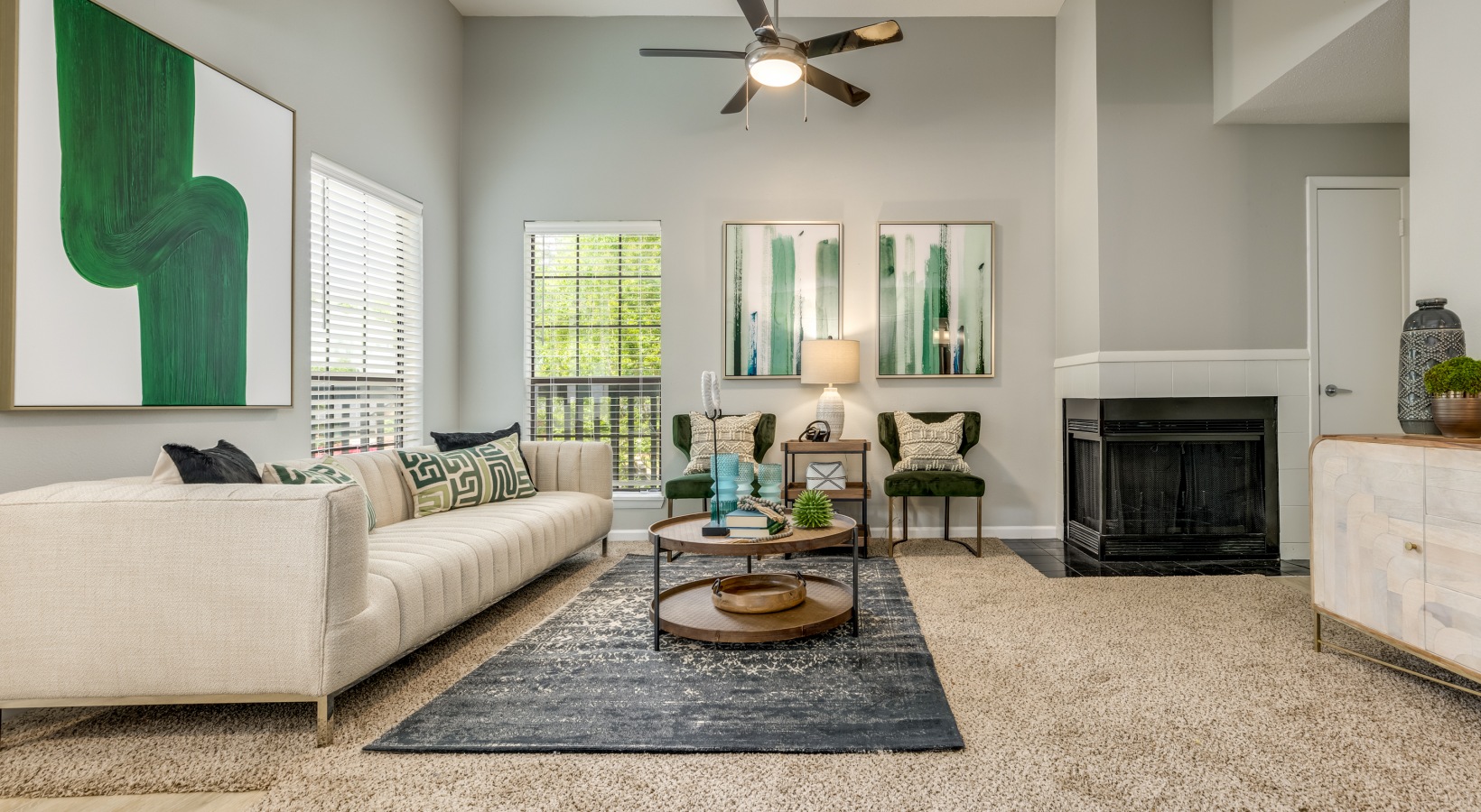a living room with a fireplace and a ceiling fan at The Quinn on Ravenglass