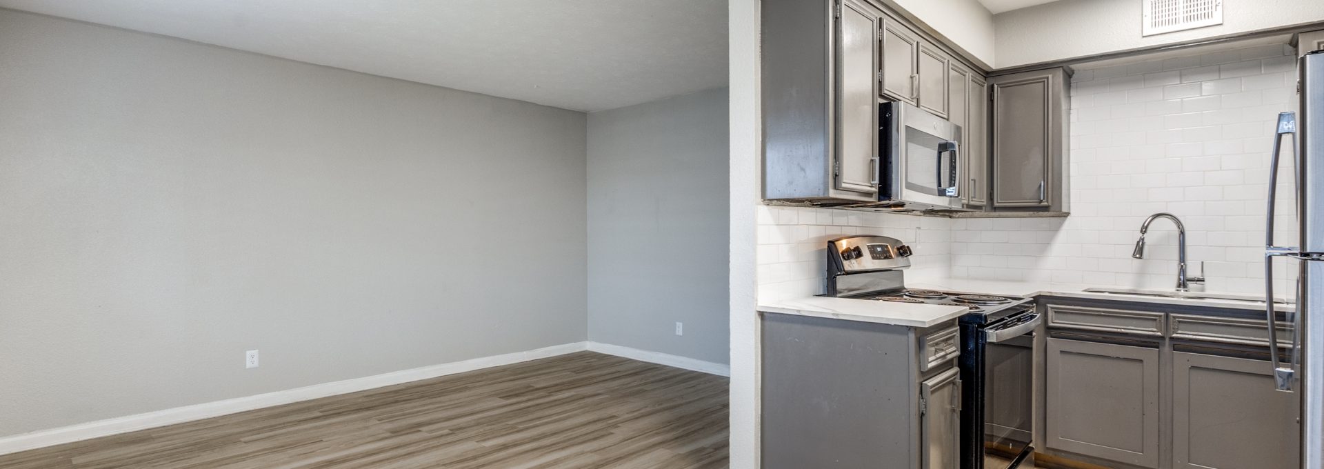 an empty kitchen with gray cabinets and stainless steel appliances at The Las Ventanas