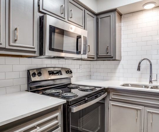 a kitchen with stainless steel appliances and gray cabinets at The Las Ventanas