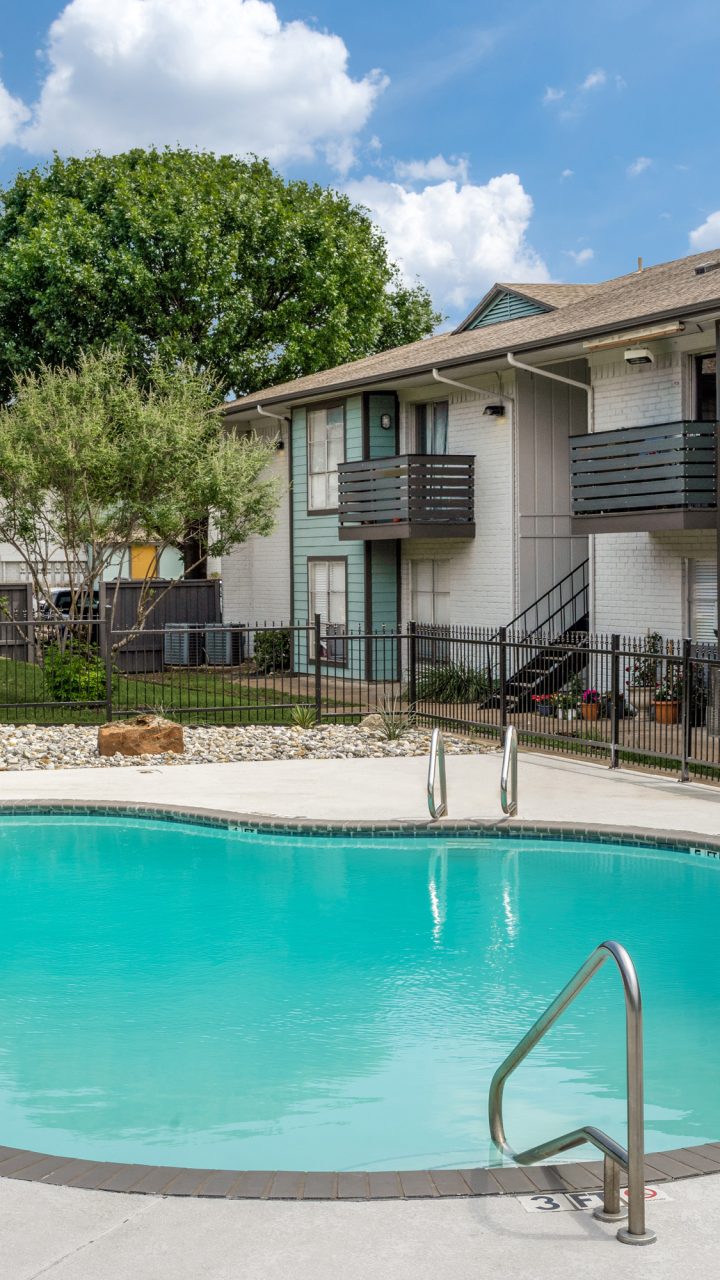 Courtyard swimming pool surrounded by landscaped grounds and apartment buildings at Las Ventanas in Duncanville, Texas