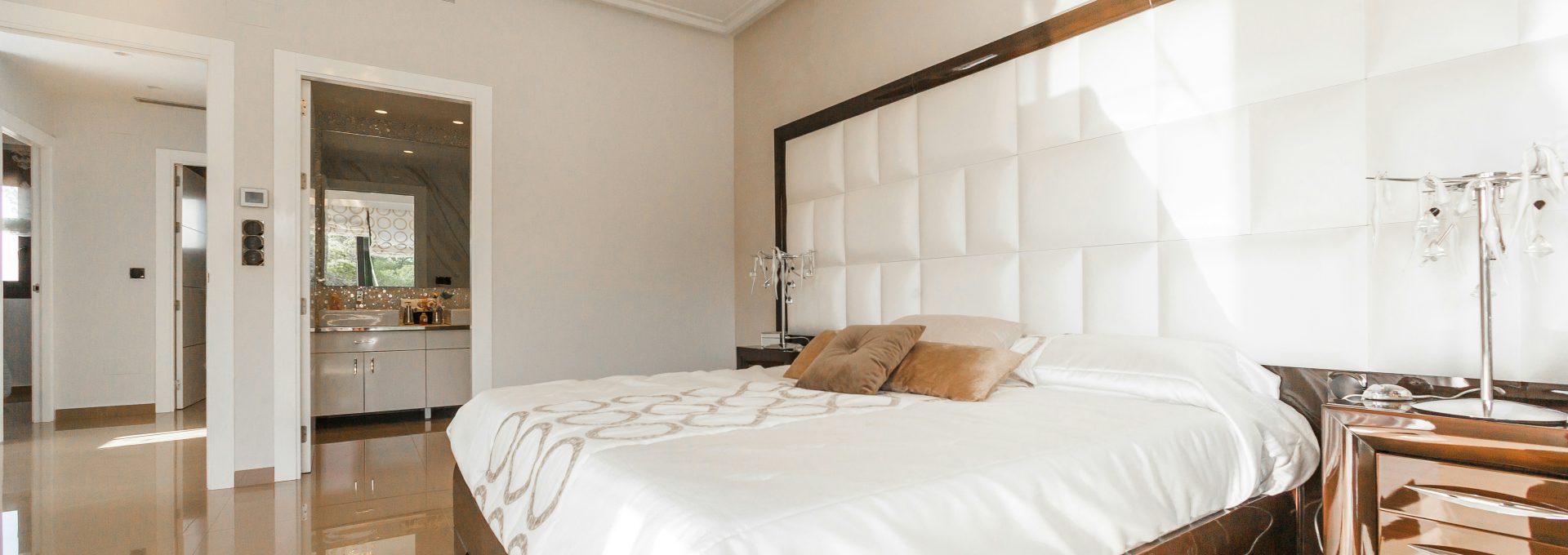 brown wooden bed frame with white cover beside brown wooden nightstand