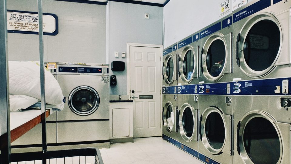 a row of washers and dryers in a laundry room