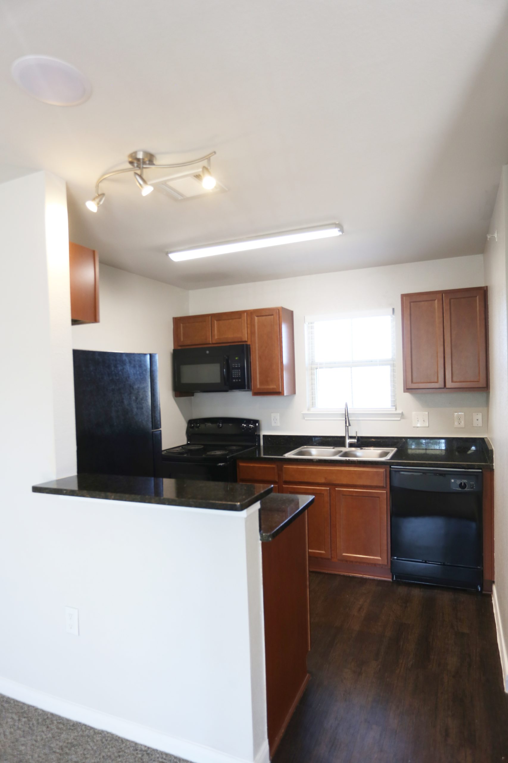 a kitchen with black appliances and wood cabinets at The Wilson Place 